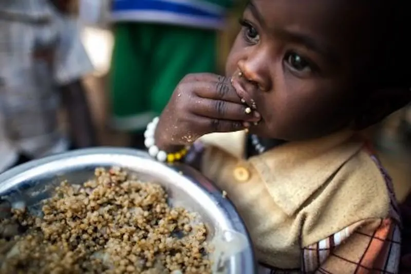 Un niño recibe una raci&oacute;n de comida en un campamento de desplazados en Rwanda. / ONU
