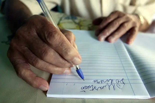 Una persona mayor aprende a escribir.