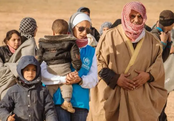 Refugiados sirios siendo ayudados por un agente de la Acnur. / RR SS