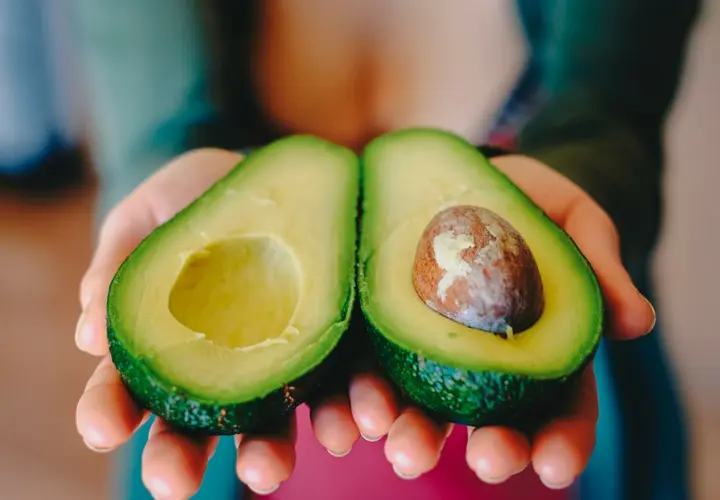 Mujer mostrando un aguacate./ Pixabay.
