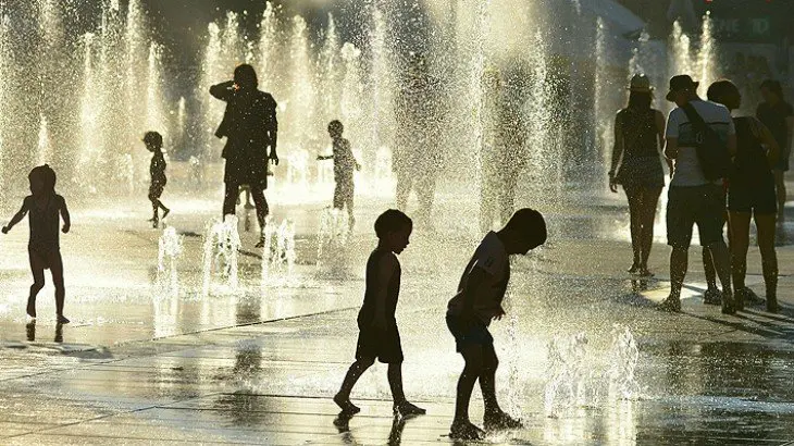 Ni&ntilde;os juegan con agua en una plaza de Montreal. / Twitter