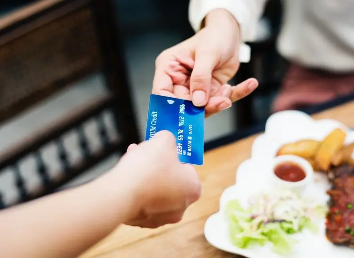 Dos personas sosteniendo una tarjeta de cr&eacute;dito. / Pexels.com.