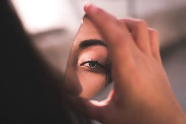 Una mujer vi&eacute;ndose en el espejo. / Pexels.com.