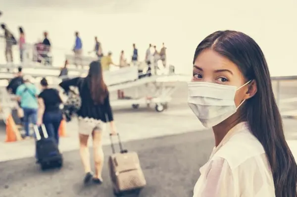 Mujer viajando con mascarilla. / Pixabay.