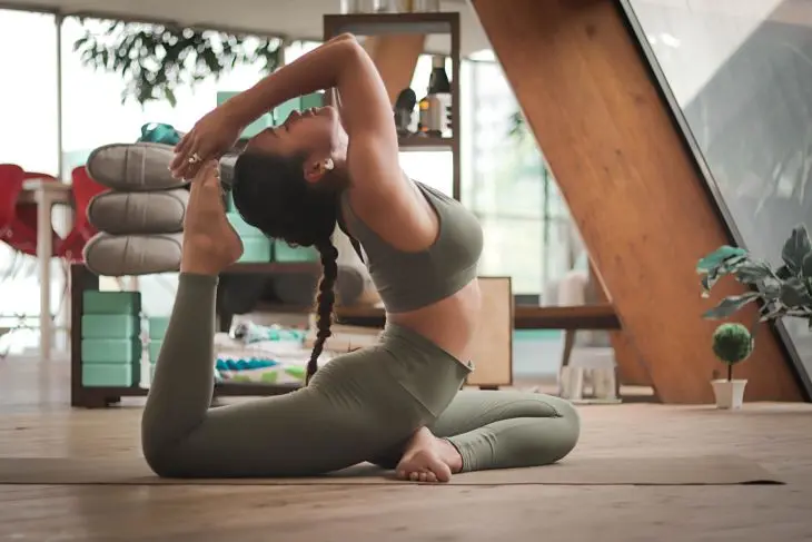 Una mujer haciendo una pose de yoga. / Unplash.