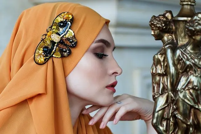 Mujer pensativa con un adorno de mariposa en la cabeza./ Anastasia Gepp en Pixabay.
