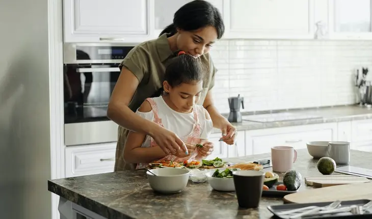 Madre cocinando con su hija. / Pexels.com.