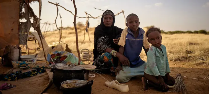 Una familia desplazada sentada frente a su tienda de campa&ntilde;a en un campamento informal de Bagoundi&eacute;, en Mal&iacute; / ONU
