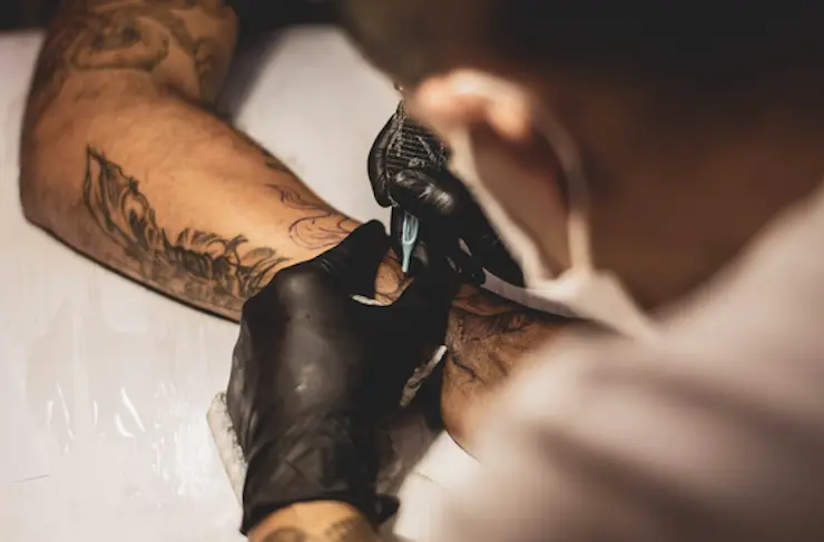 Tatuador haciendo un tatoo.