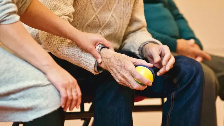 Mujer agarrando del brazo a un anciano. / Matthias Zomeren Pexels