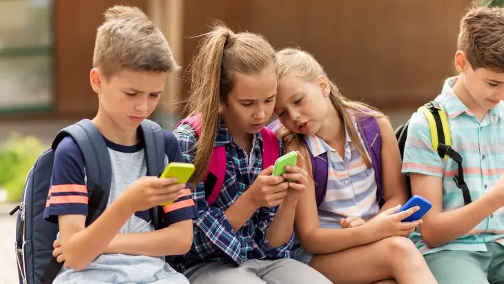 Menores usando sus tel&eacute;fonos. / Getty Images.