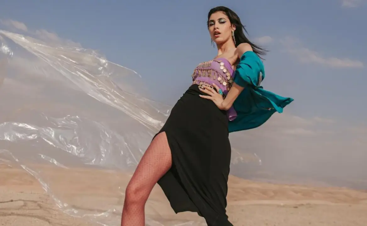 Mujer usando falda larga negra con abertura frontal.
