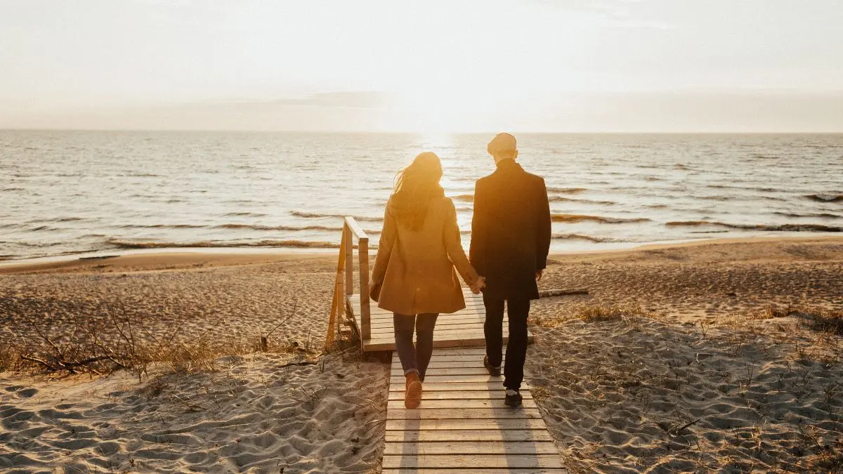 Una pareja camina hacia el mar. / MundiStyle.