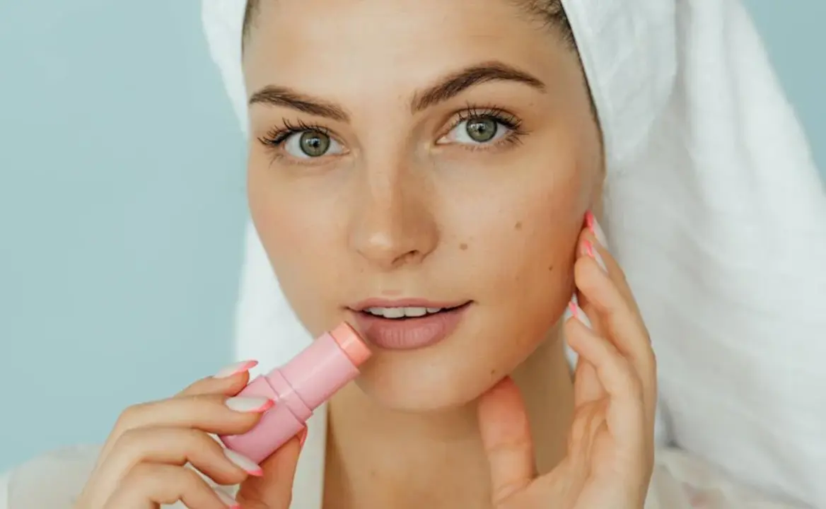 Mujer usando b&aacute;lsamo labial hidratante.