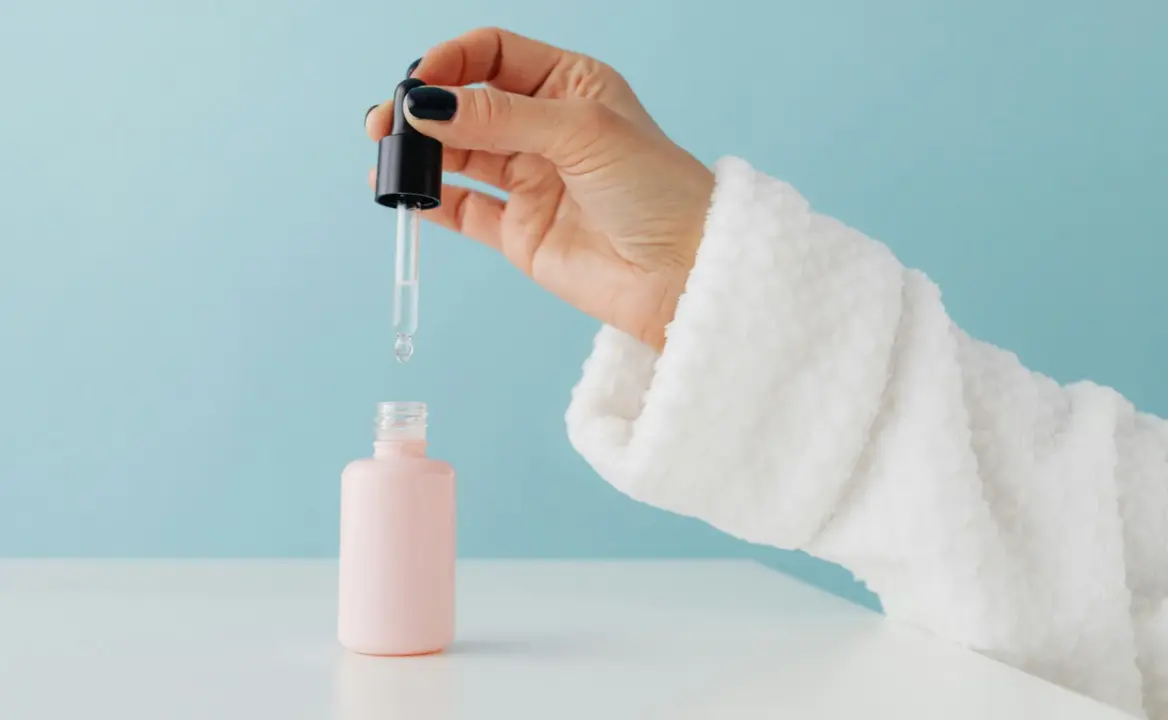 Envase rosa tipo serum con gotero aplicador.
