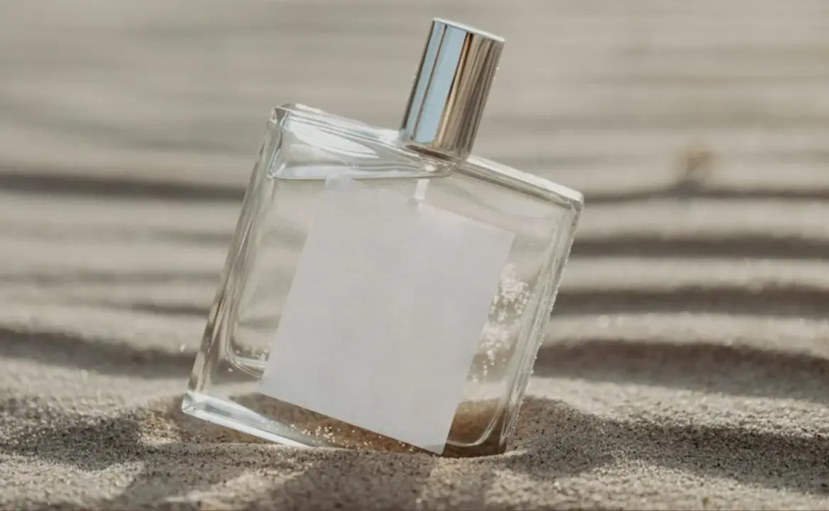 Envase de perfume enterrado en la arena.