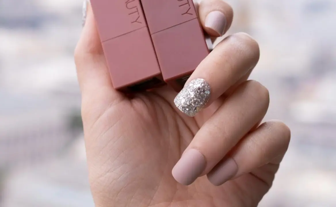 U&ntilde;as con esmalte de u&ntilde;as brillante en tono plateado.
