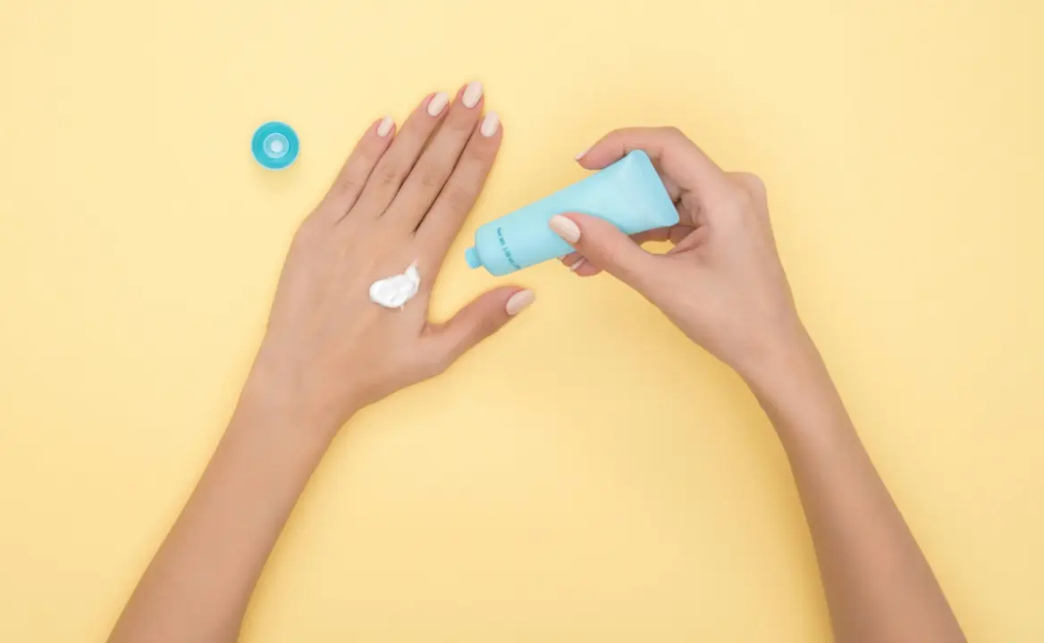 Manos con crema hidratante.