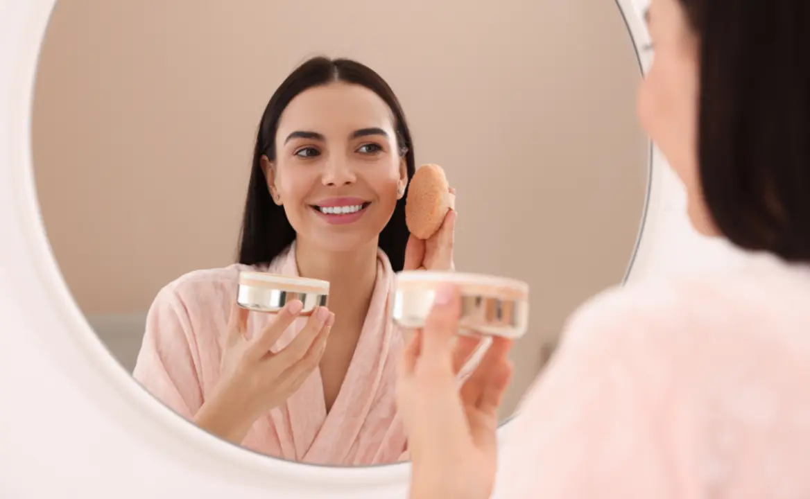 Mujer con esponja facial y base en polvo.