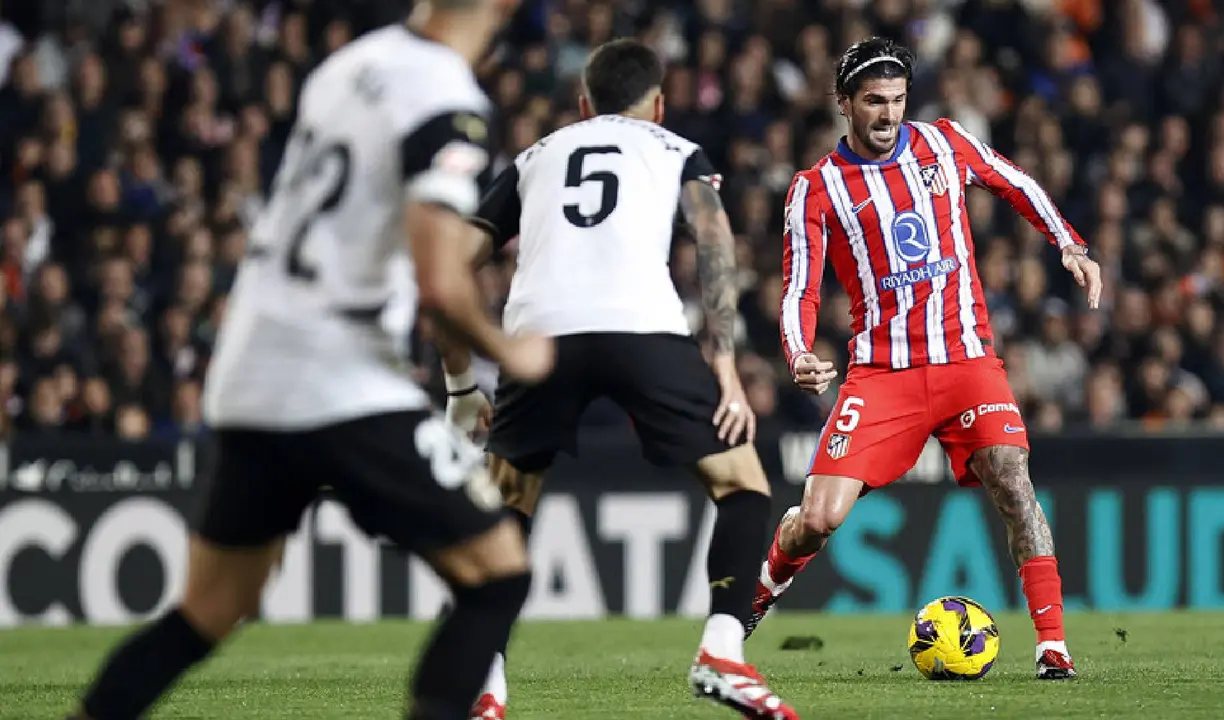 Rodrigo de Paul rodeado por futbolistas del Valencia. /  www.atleticodemadrid.com