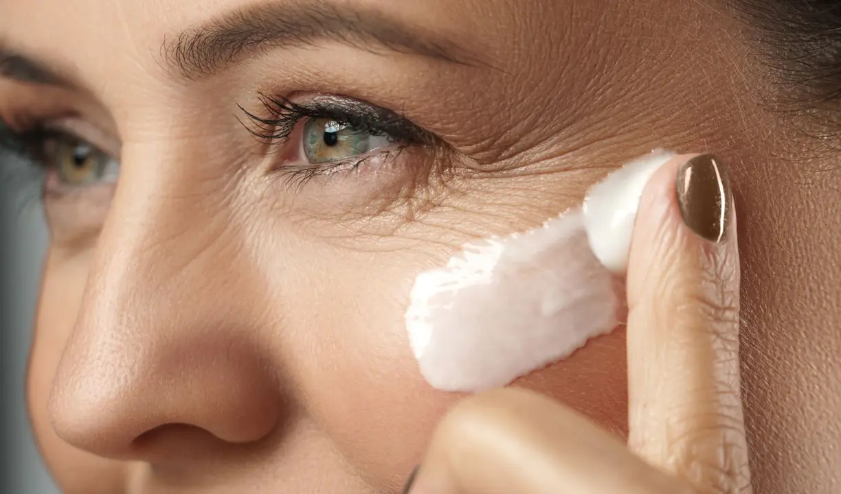 Una mujer aplicando crema en el rostro. / Mundistyle.