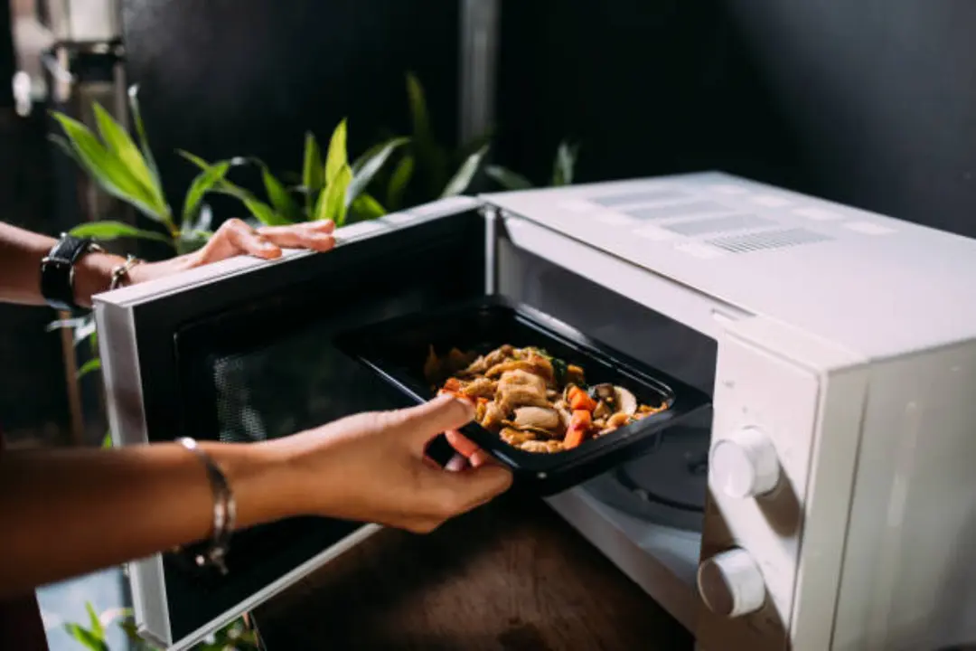 Una persona calienta comida en el microondas. / iStock.