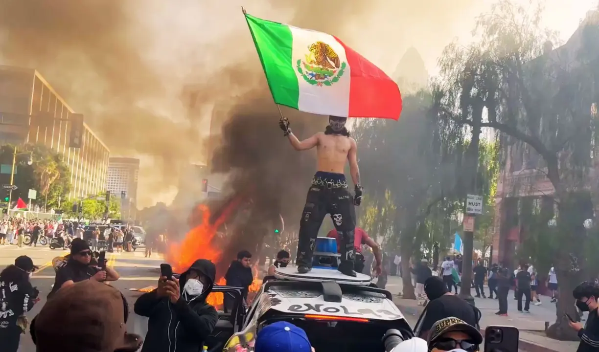 Un hombre durante las protestasen EE UU llevando la bandera de M&eacute;xico. / X.