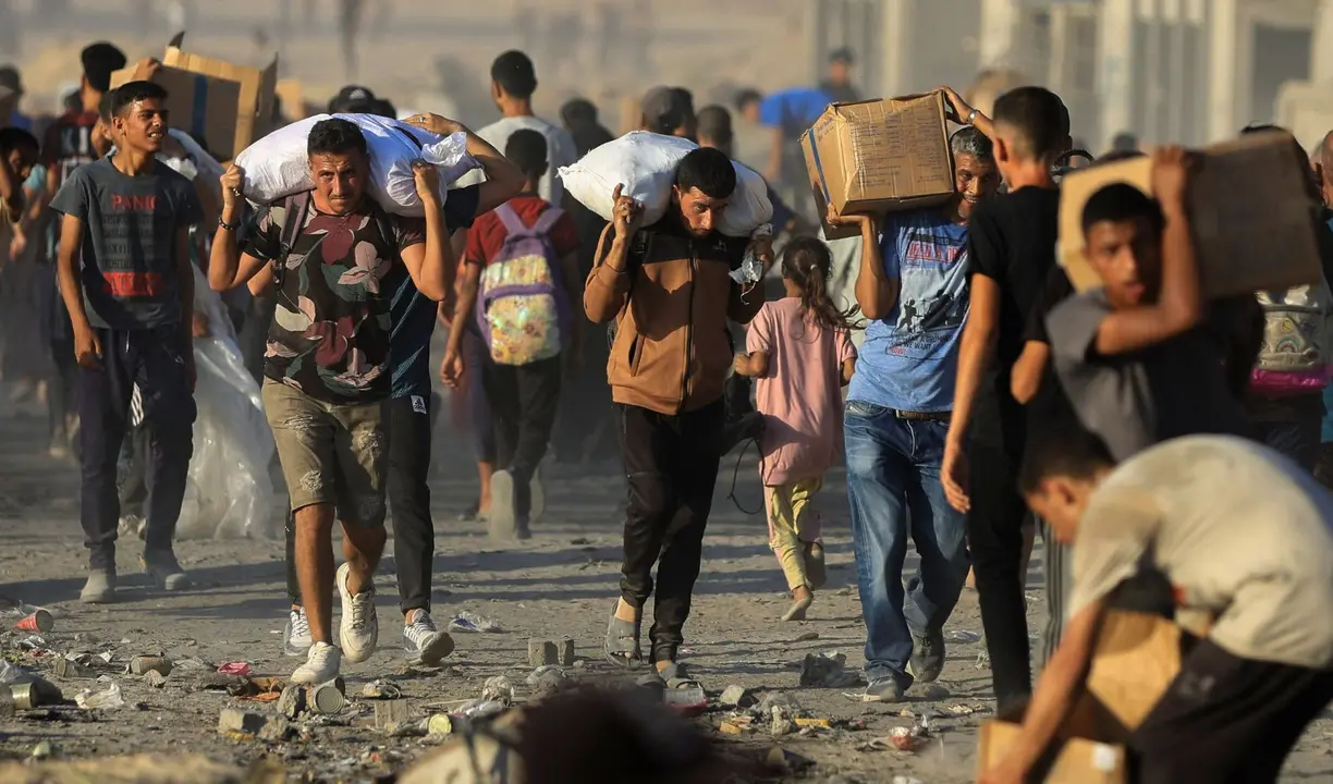 Gazat&iacute;es retiran comida en medio de la guerra. / @AlArabiya_Eng.