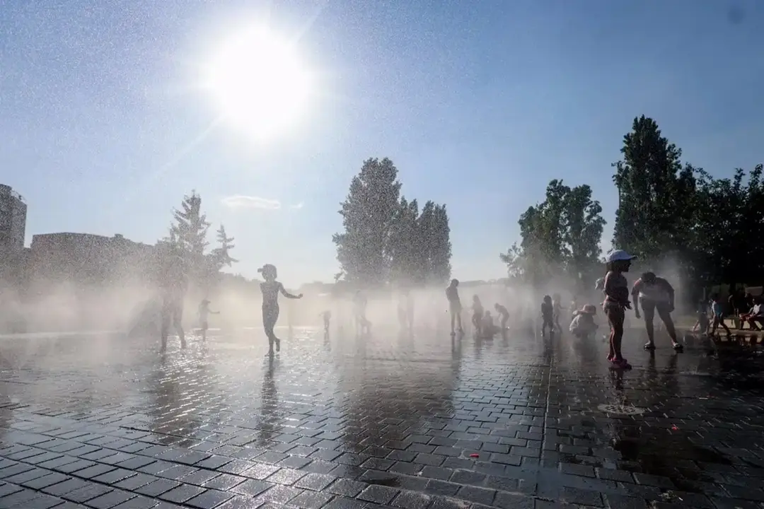 Ni&ntilde;os jugando con el agua para refugiarse del calor. / RR. SS.