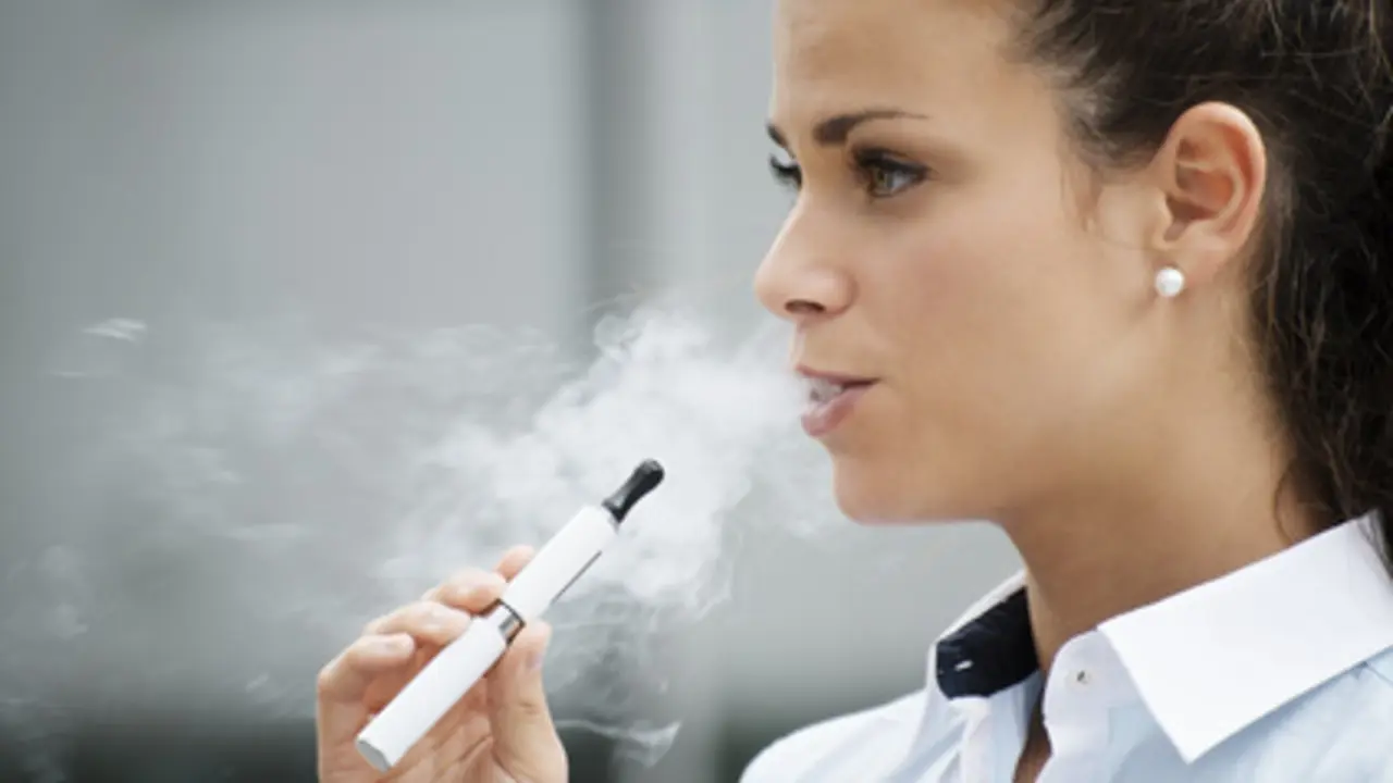 Una joven fuma un cigarrillo electr&oacute;nico.