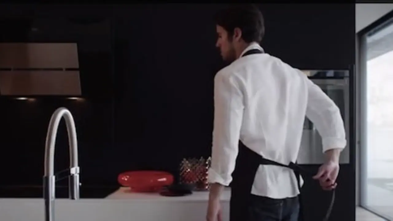 Hombre cocinando con horno Franke.
