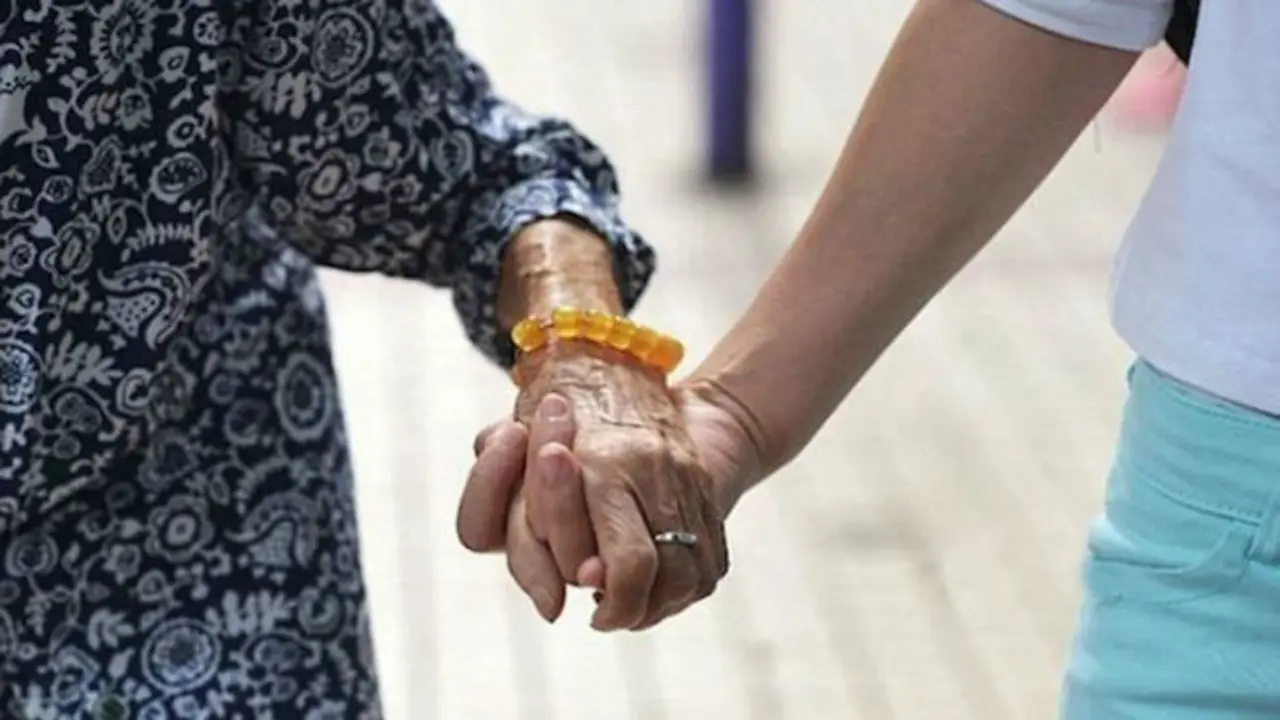 Abuela de la mano de una persona. / RR SS