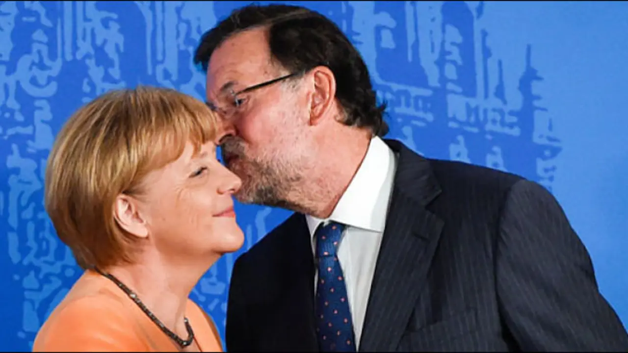 Angela Merkel recibe un beso de Mariano Rajoy.