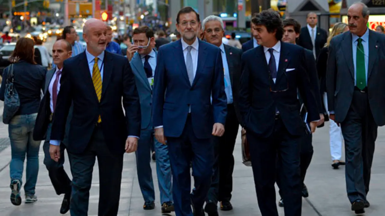 Moragas camina a la izquierda de Rajoy.