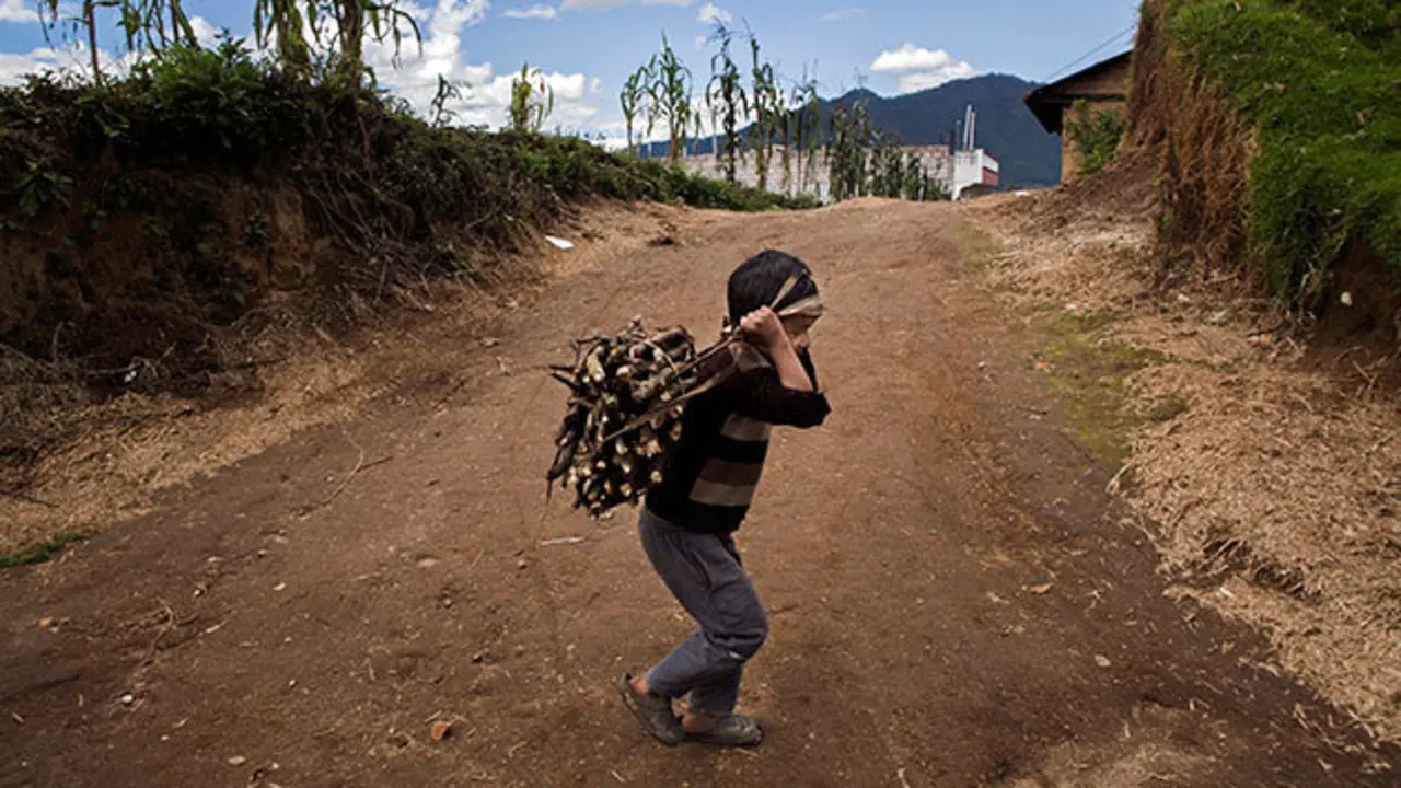 A young boy gathers wood by the side of the road in Quetzaltenango, Guatemala. The area has one of the highest levels of child migration in the country; mostly economic refugees with poverty levels in the region as high as 93 percent. In addition, a large population of Guatemalans from the area are already living in the United States and Mexico. Photo by Katie Orlinsky.