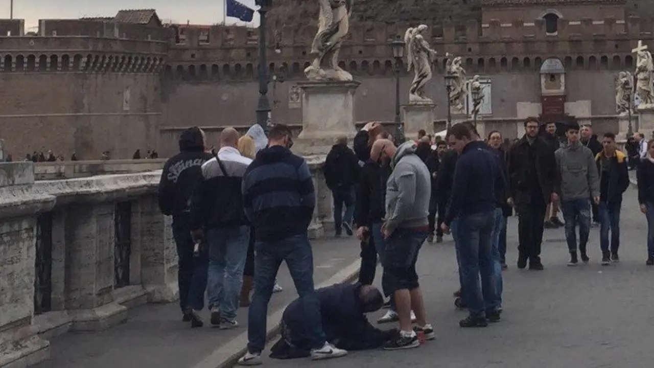 Aficionados del Sparta orinando sobre una mendiga