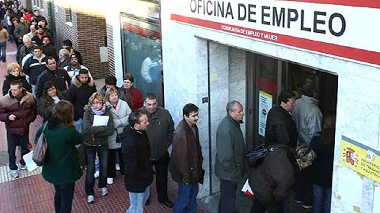 Personas haciendo cola en oficina de empleo en España.
