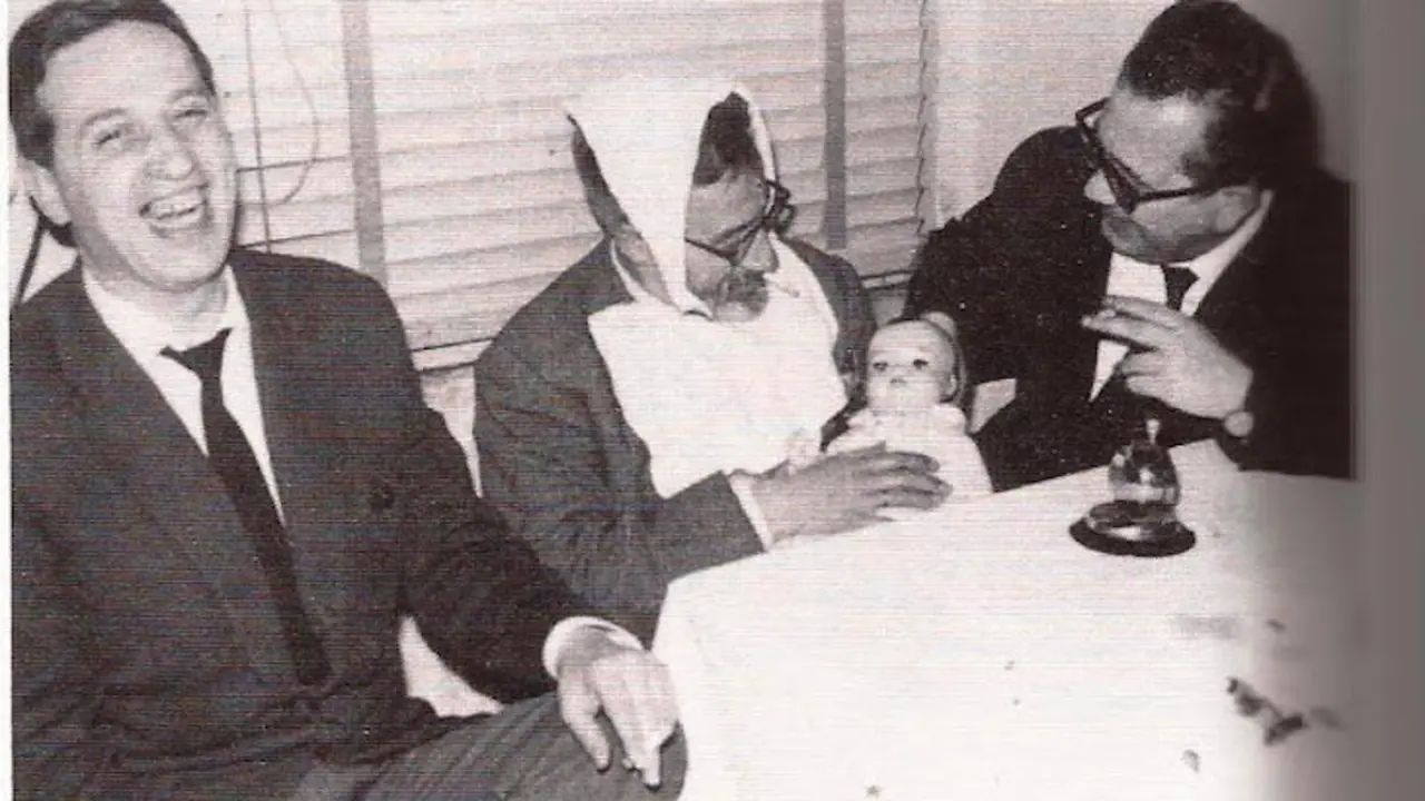 A la derecha, &Aacute;lvaro Paradela "escenificando" el papel de niñera, y Mario Couceiro que celebra la humorada, en una reunión de periodistas. A la izquierda, el reportero ferrolano Andr&eacute;s Par&iacute;s Rico.