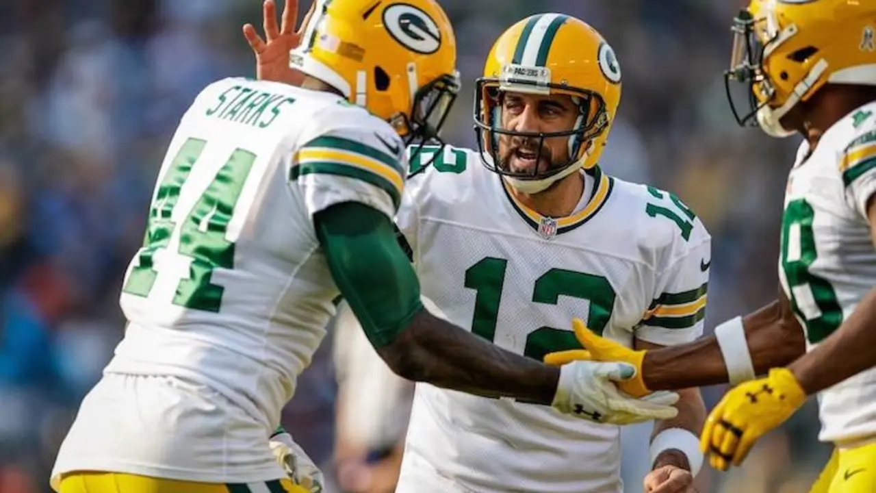 Aaron Rodgers (12) anima a sus compañeros durante un partido de esta temporada. : Facebook.