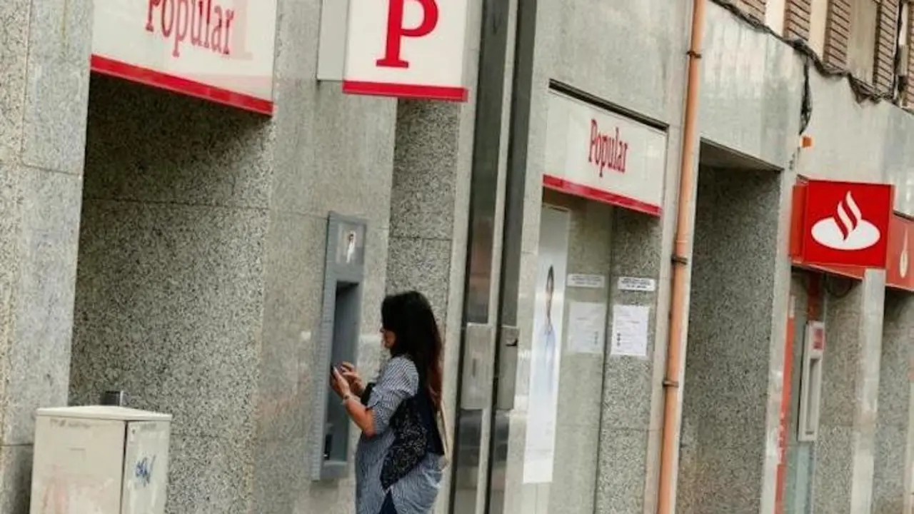 Una mujer retira dinero de un cajero del Banco Popular. / Twitter