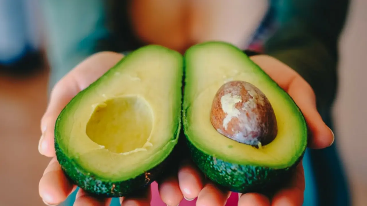 Mujer mostrando un aguacate./ Pixabay.