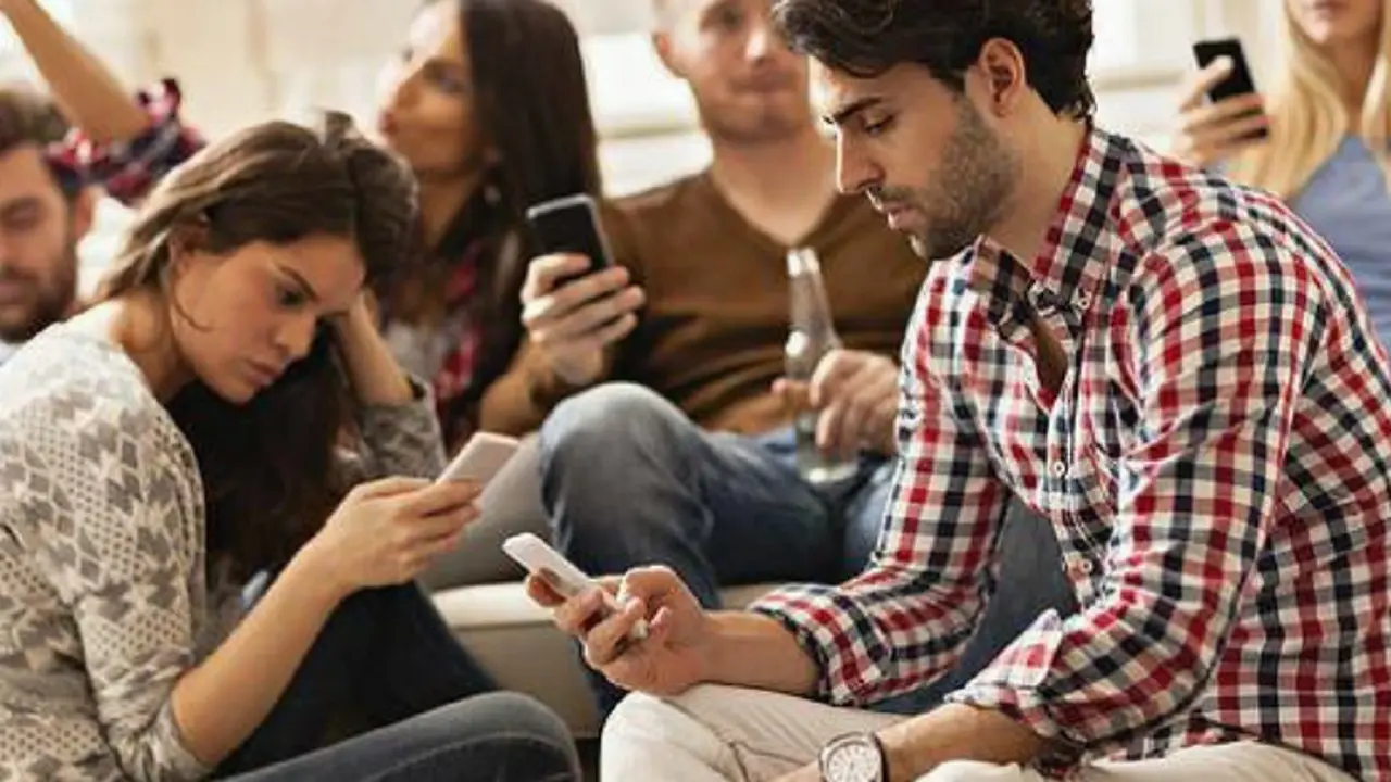 Millennials utilizando sus m&oacute;viles en una reuni&oacute;n. RR SS.