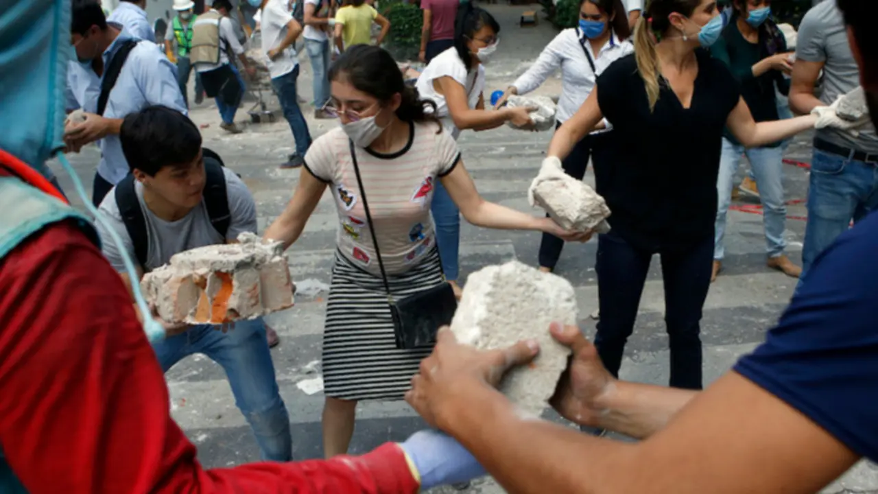 Mexicanos ayudando a quitar los escombros luego del sismo. Twitter.