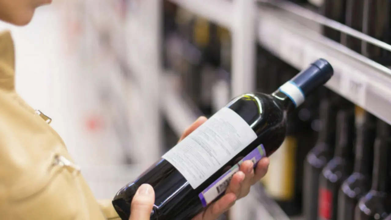 Mujer seleccionando un vino. RR SS.