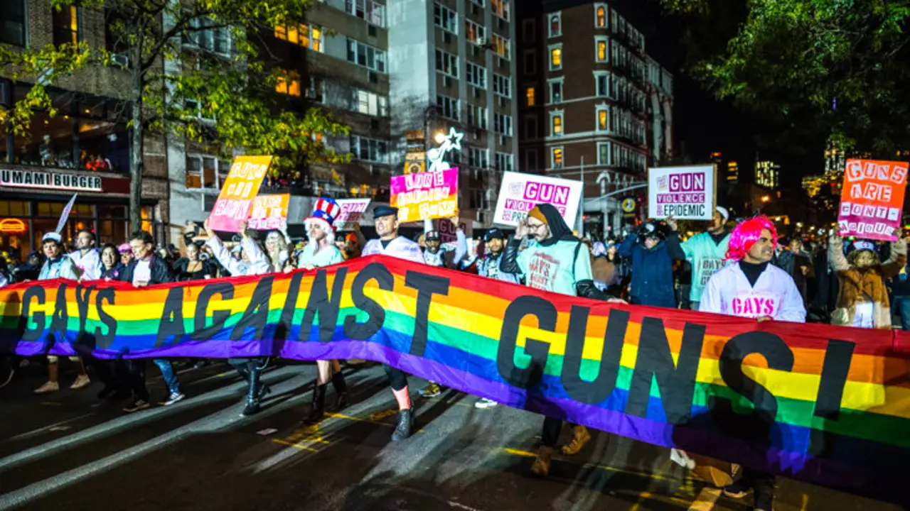 Participantes del desfile de Halloween portan una enorme bandera con la leyenda "Gays contra las Armas!" en el  Greenwich Village de Nueva York el 31 de octubre de 2017. / Enrique Shore