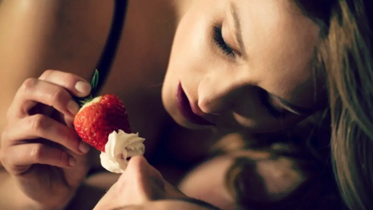 Pareja compartiendo un fresa. Foreplay