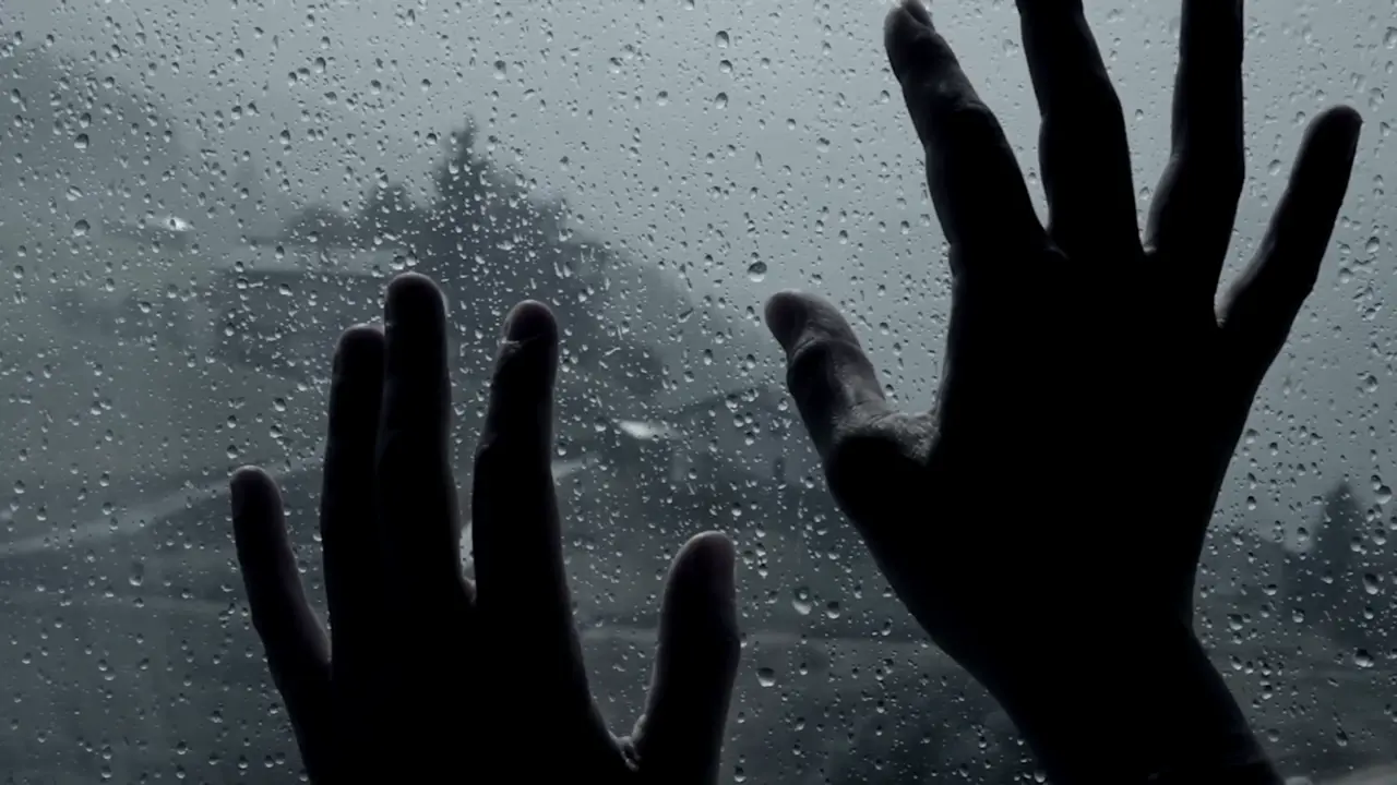 closeup-of-hands-in-front-of-rain-concept-of-sadness_n1rnaddhg__F0000