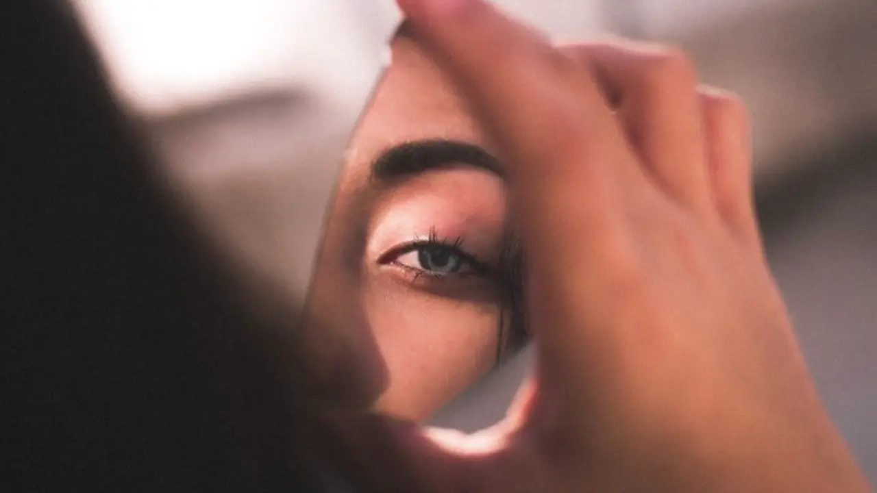 Una mujer vi&eacute;ndose en el espejo. / Pexels.com.
