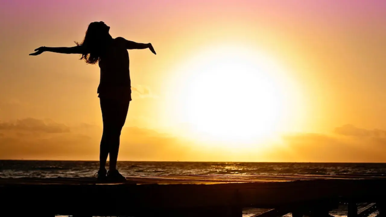 Una mujer disfruta de una puesta de sol. / Pixabay