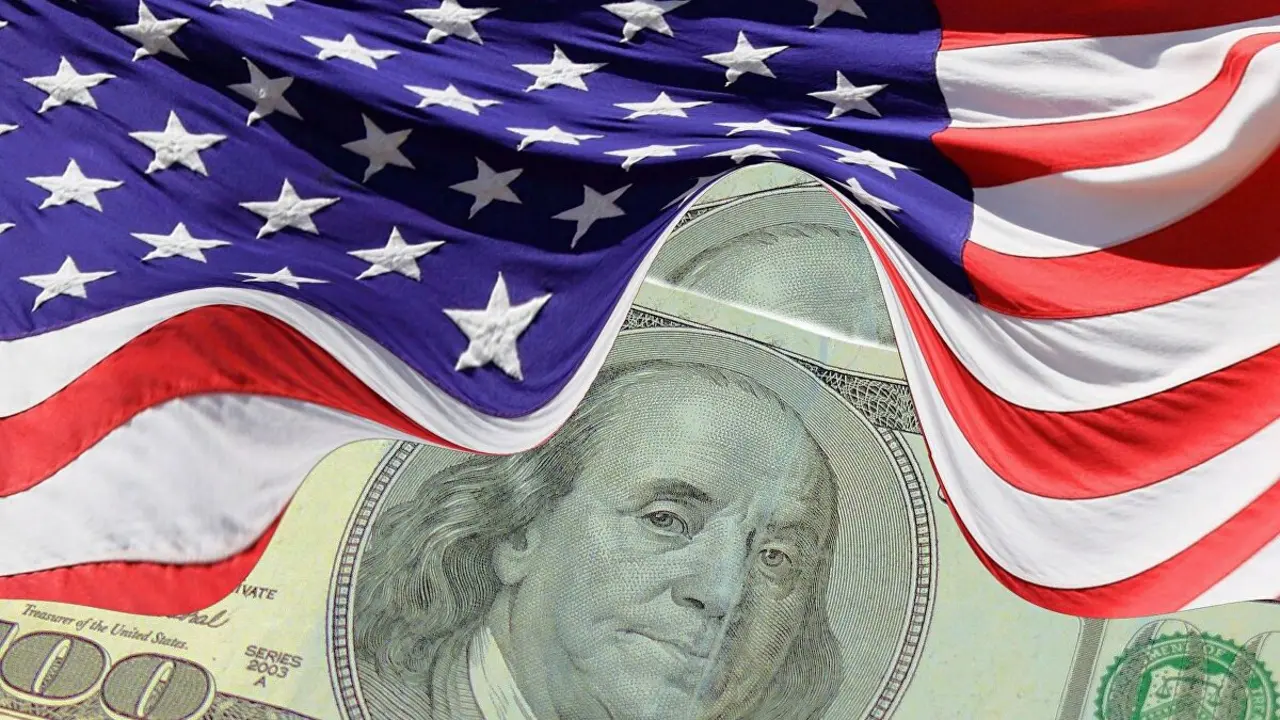 Un billete en dólares bajo la bandera de los EE UU. / Sputnik
